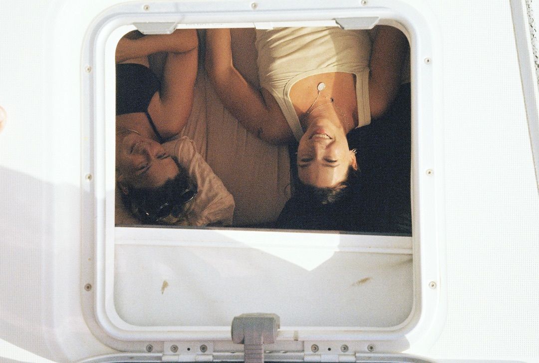 Two crew members laughing, seen through an overhead hatch
