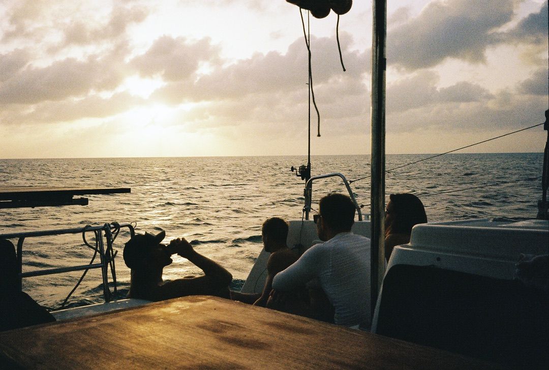 Crew silhouetted on deck at sunset